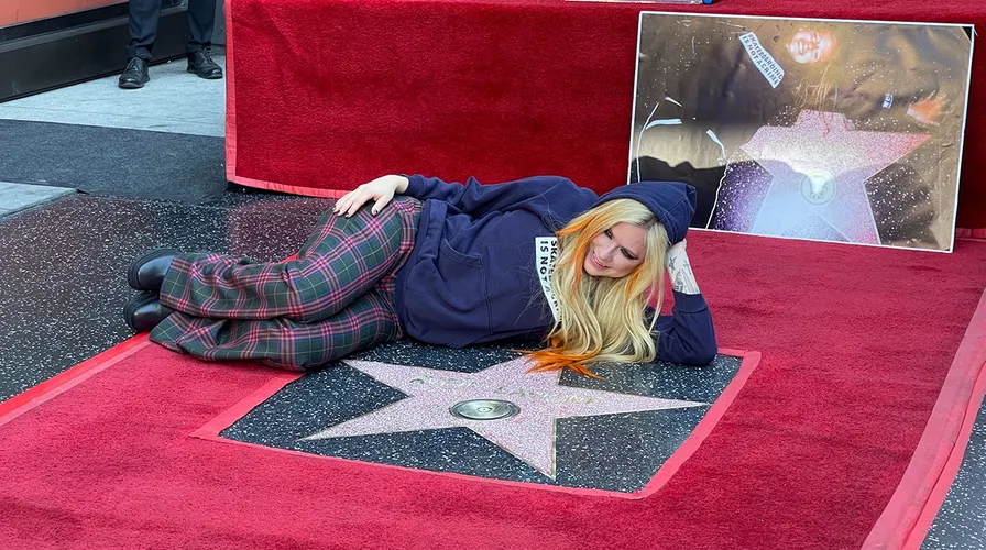 Avril Lavigne mengenakan hoodie yang ia pakai saat berusia 16 tahun ketika menerima bintang di Hollywood Walk of Fame