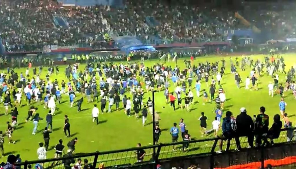 Aremania menyerbu ke tengah lapangan stadion yang menyebabkan bentrok.