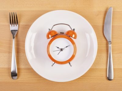 weight loss or diet concept. stock image of alarm clock on plate